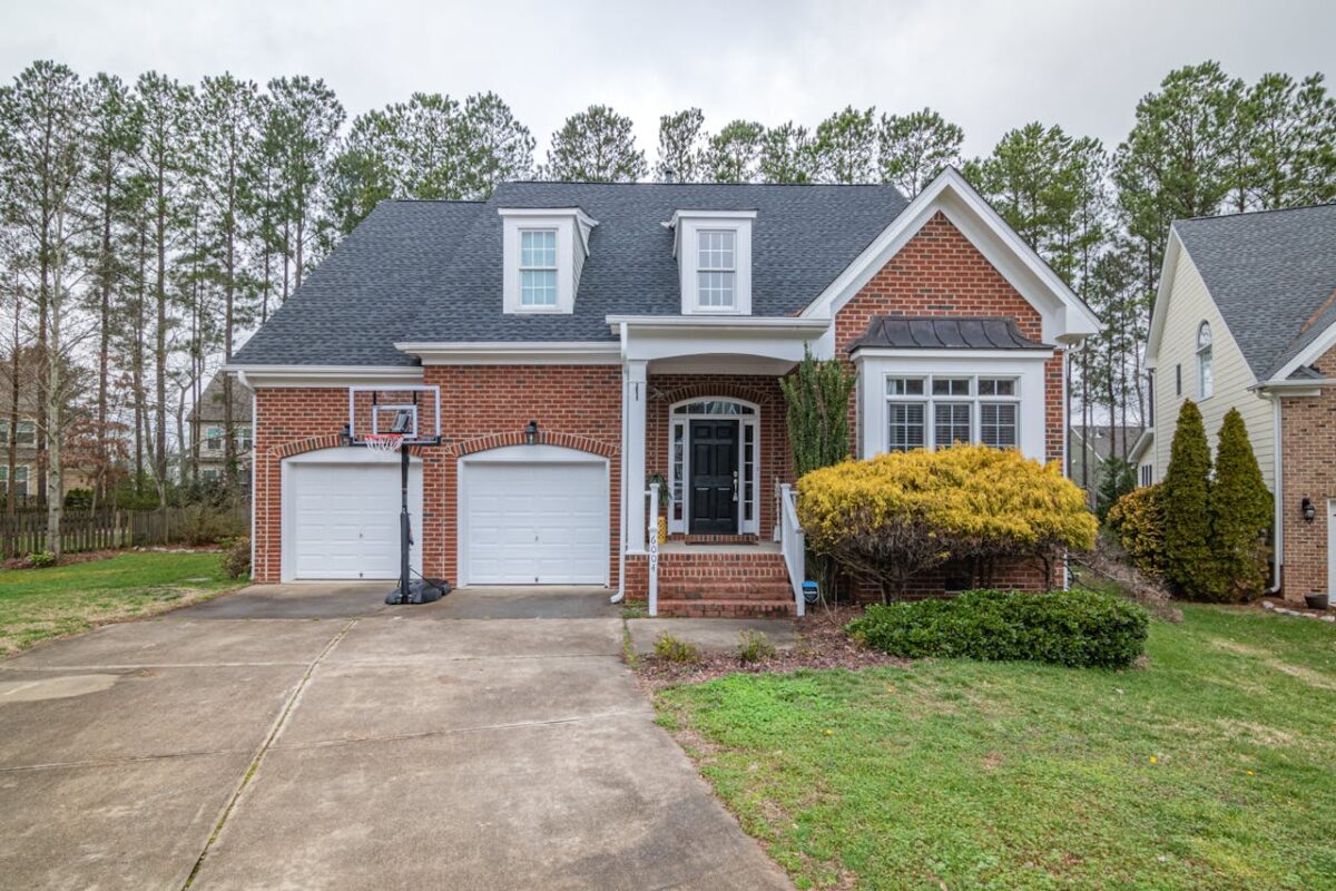 services-02 Brick suburban home with garage and basketball hoop in a peaceful neighborhood.