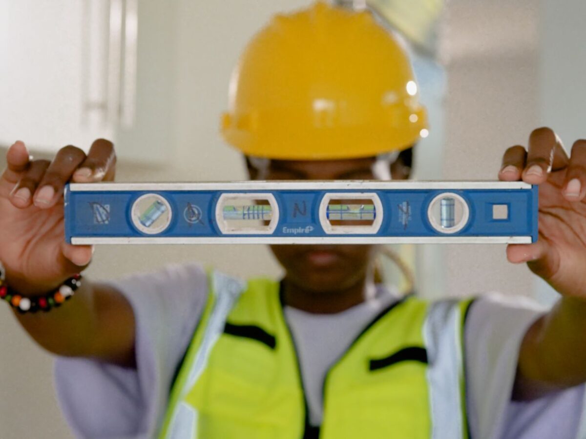 services-04 Close-up of construction worker holding a spirit level indoors.